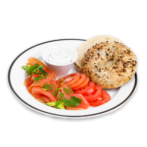 Bagel with tomatoes, smoked salmon, dill, with cream cheese on a white plate